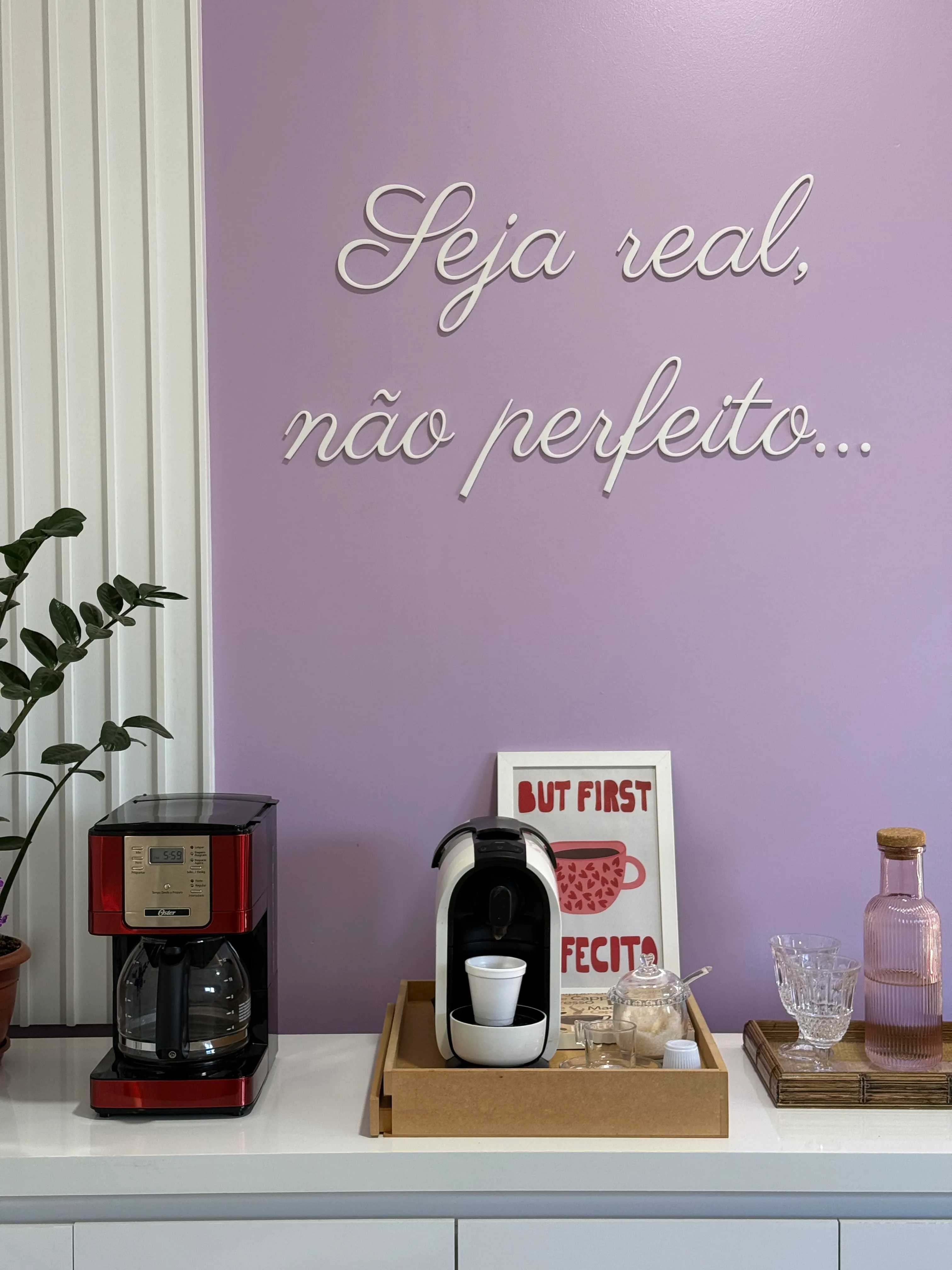 Detalhe da bancada do café com cafeteira vermelha, máquina de cápsulas e bandeja de madeira
